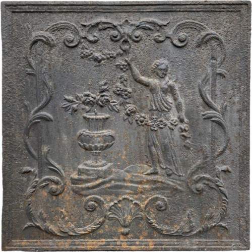 18th century fireback representing a female figure with a flower garland next to an antique vase
