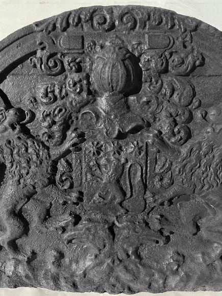 A semicircular cast iron fireplace plaque, decorated with a coat of arms, surmounted by a helmet and framed by lions. A semicircular cast iron fireplace plaque, decorated with a coat of arms, surmounted by a helmet and framed by lions.-2