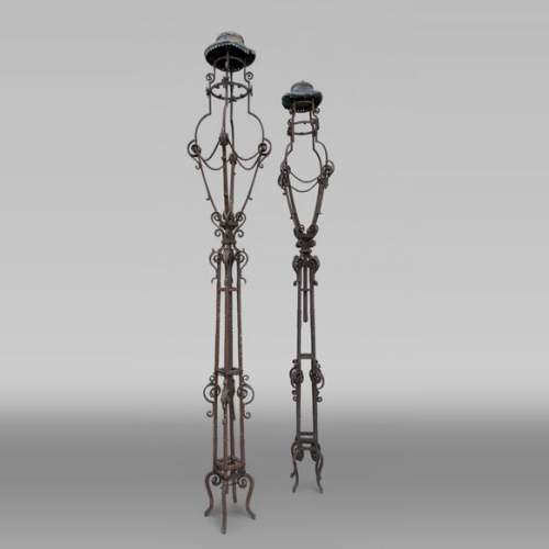 Pair of wrought iron lighting candelabra with openwork shafts, in the Renaissance taste