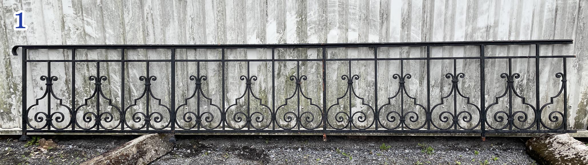 Set of wrought-iron railings featuring a design of scrolls and volute terminals, including both straight and raked sections-1