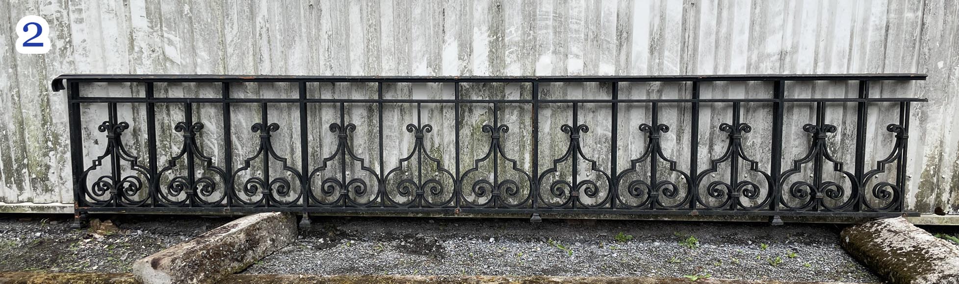 Set of wrought-iron railings featuring a design of scrolls and volute terminals, including both straight and raked sections-2