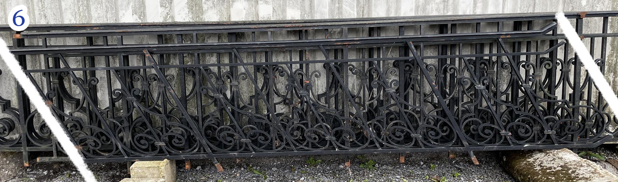 Set of wrought-iron railings featuring a design of scrolls and volute terminals, including both straight and raked sections-6