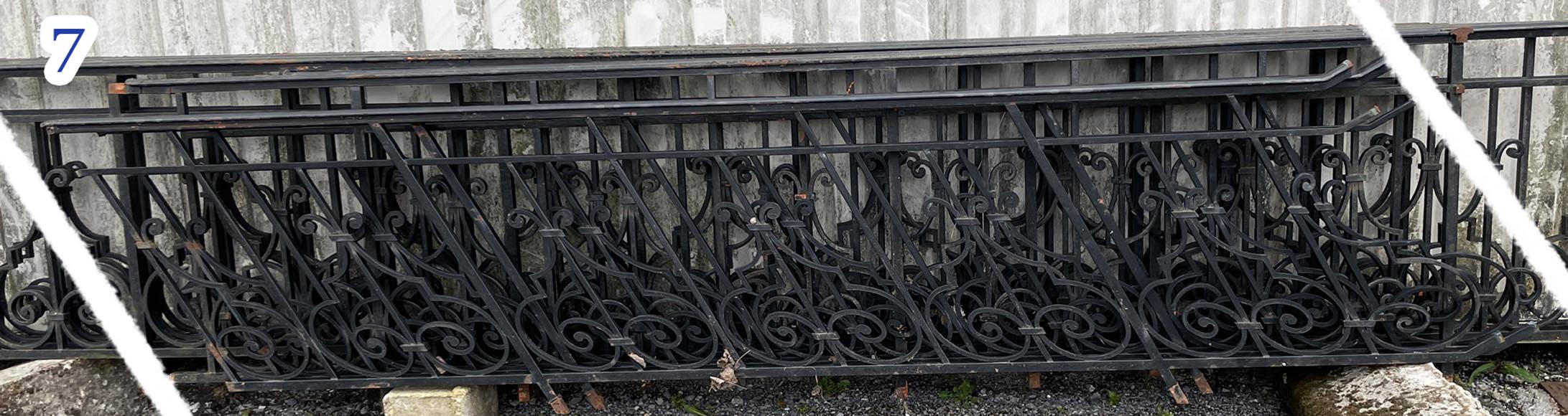 Set of wrought-iron railings featuring a design of scrolls and volute terminals, including both straight and raked sections-7