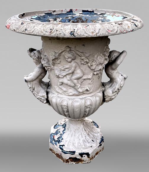 Cast iron garden vase with a frieze of cupids and handles formed as winged putti Cast iron garden vase with a frieze of cupids and handles formed as winged putti-1