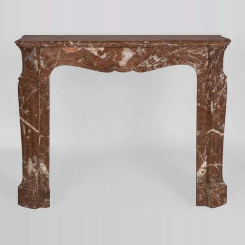 An antique Louis XV style fireplace, Pompadour model, made out of Rouge du Nord marble