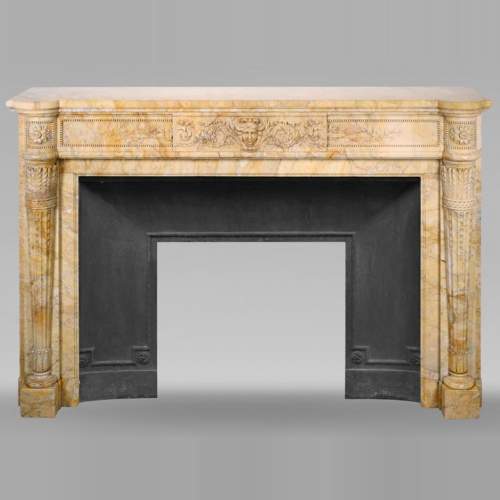 Large Louis XVI style mantel in yellow Sienna marble with entablature adorned with the head of Apollo and arrow heads on the jambs