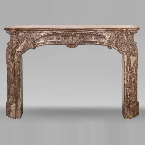 Louis XV period fireplace decorated with an asymmetrical palmette in a variation of Royal Red marble