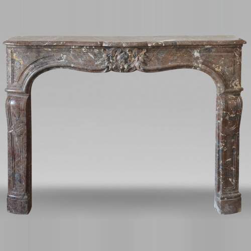 Louis XV period fireplace in Rouge Royal marble, decorated with a shell