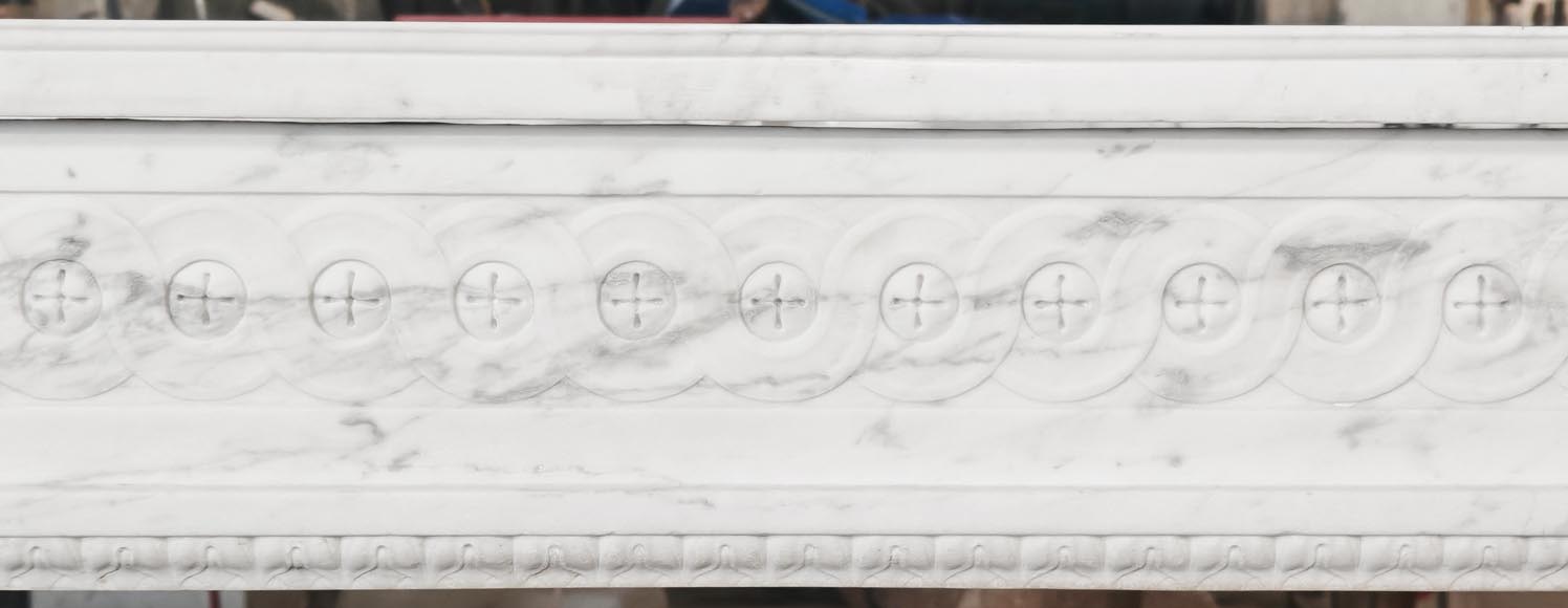 A Louis XVI period fireplace in veined Carrara marble, decorated with a Greek-style frieze. A Louis XVI period fireplace in veined Carrara marble, decorated with a Greek-style frieze.-1