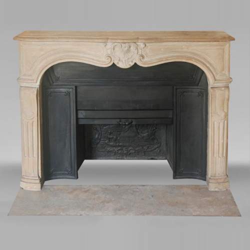Louis XV-style stone fireplace, decorated with a shell motif.