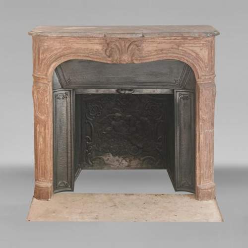Louis XV-style stone fireplace, adorned with a palmette